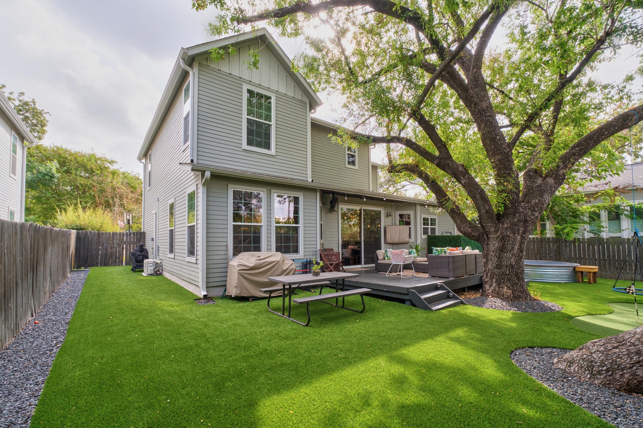 3302 Funston Street Austin, TX 78703 - Photo 25 of 35 Back of house featuring a fenced backyard, a wooden deck, an outdoor living space, a hot tub, and board and batten siding