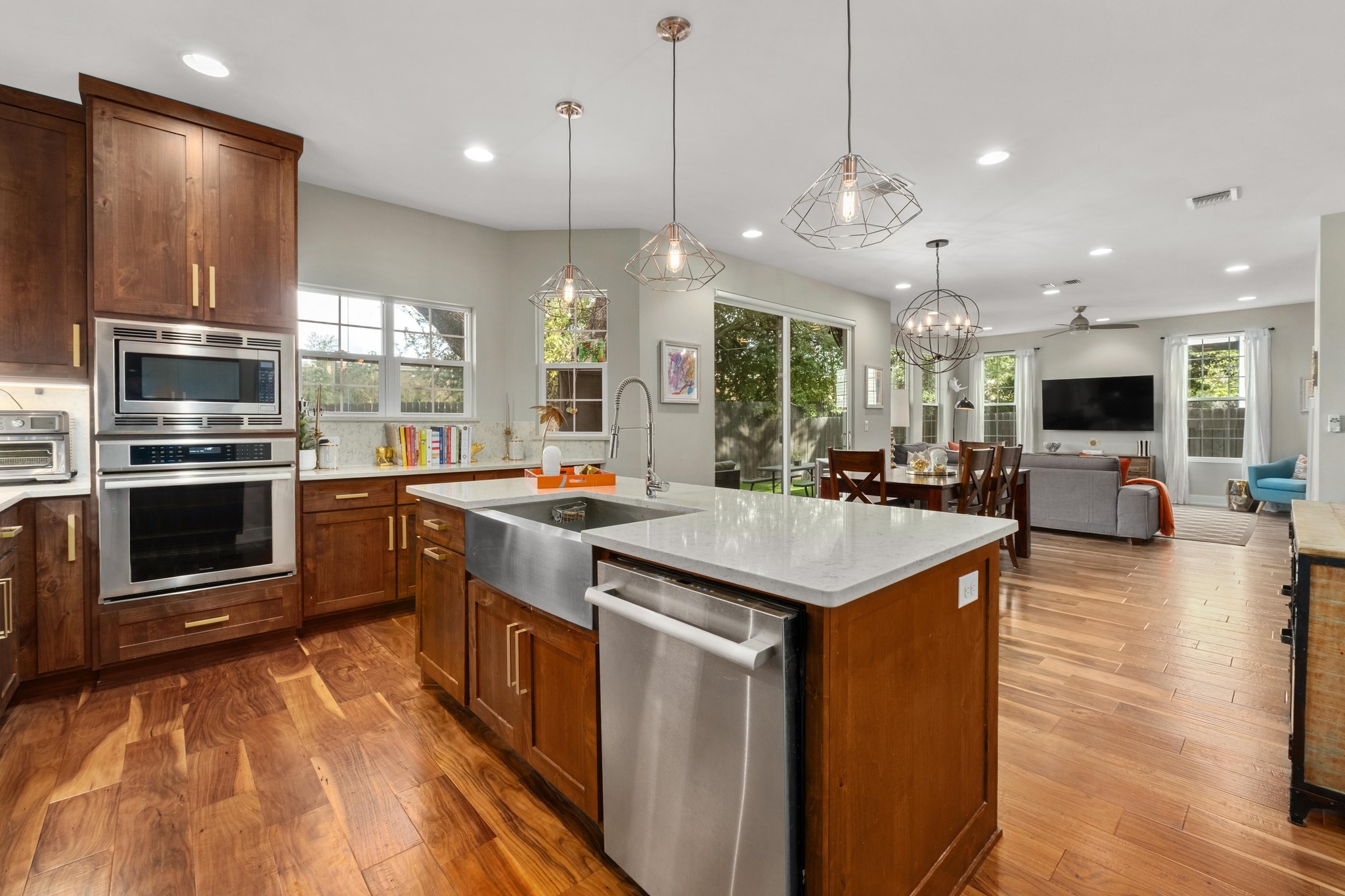 3302 Funston Street Austin, TX 78703 - Photo 34 of 35 Kitchen featuring brown cabinets, open floor plan, stainless steel appliances, light stone countertops, and dark wood-style floors
