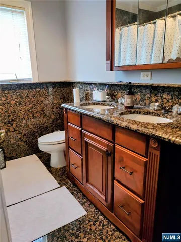 a bathroom with a sink a toilet and a window