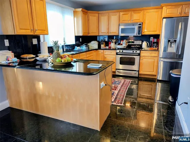 a kitchen with stainless steel appliances a stove a sink refrigerator and a microwave