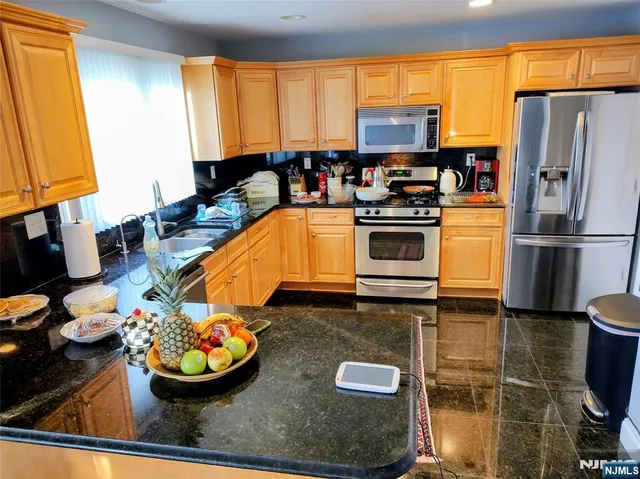 a kitchen with stainless steel appliances a stove a sink and a refrigerator