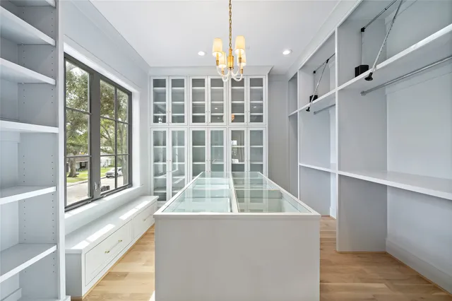wooden floor in an empty room with a fireplace and a window