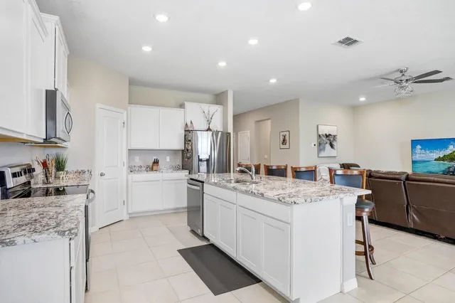 a kitchen with stainless steel appliances granite countertop a stove a sink and a microwave