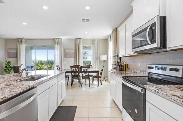 a view of kitchen with microwave stove refrigerator and dining table