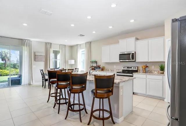 a kitchen with a sink and chairs
