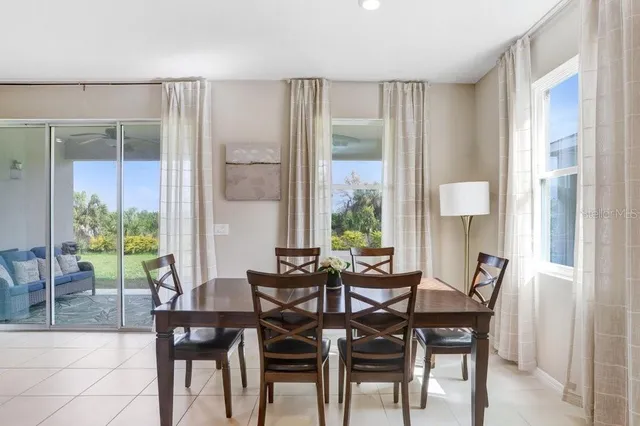 a kitchen with a dining table chairs and white appliances