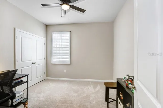 a view of a workspace with furniture and a window