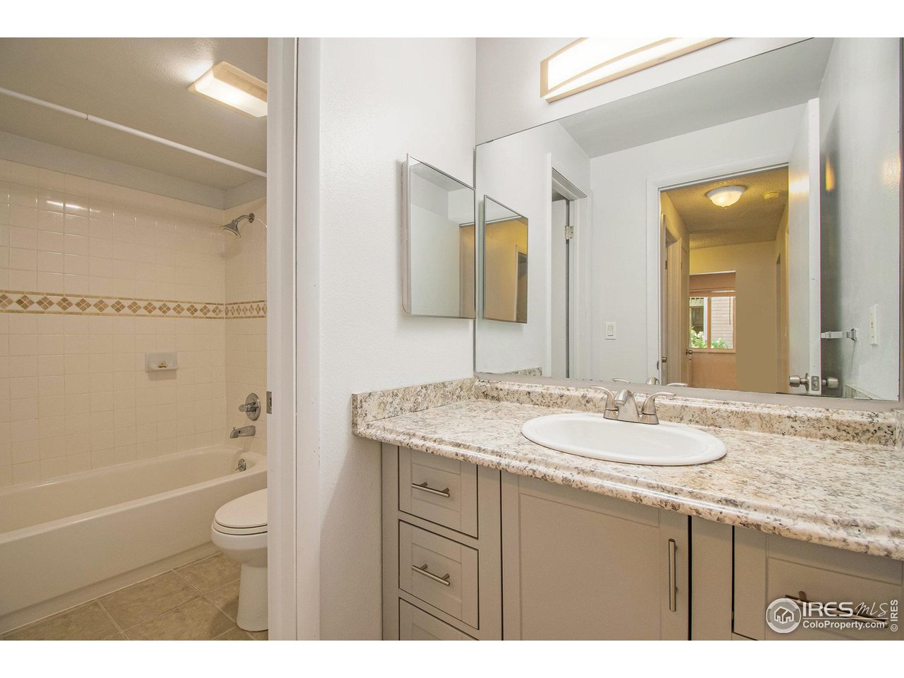 4068 South Atchison Way, Unit 101 Aurora, CO 80014 - Photo 6 of 12 a bathroom with a granite countertop sink toilet and shower