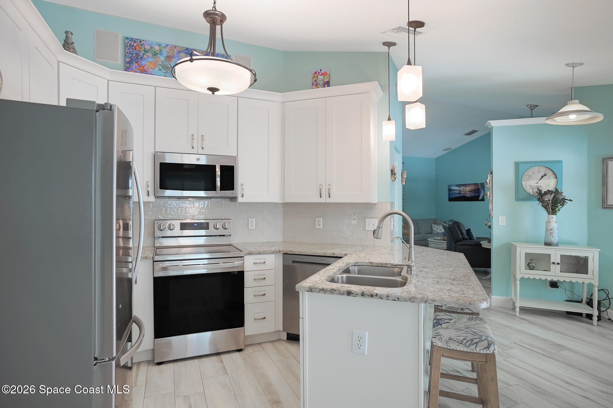103 Matanzas Road Melbourne Beach, FL 32951 - Photo 12 of 37 a kitchen with stainless steel appliances a stove a sink island and a refrigerator