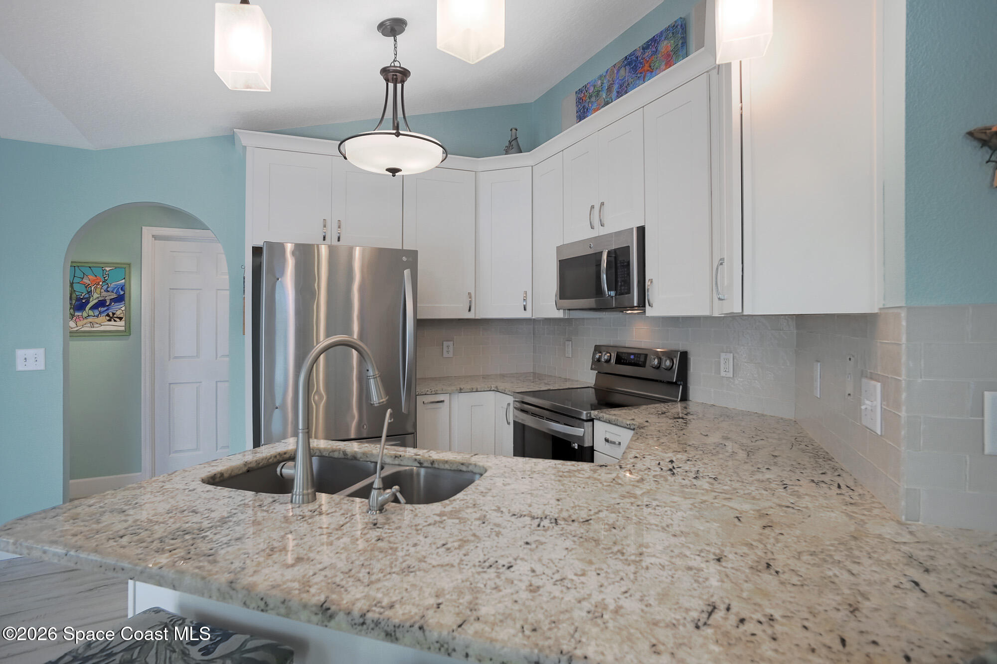 103 Matanzas Road Melbourne Beach, FL 32951 - Photo 13 of 37 a kitchen with stainless steel appliances granite countertop a refrigerator a stove a sink and a refrigerator