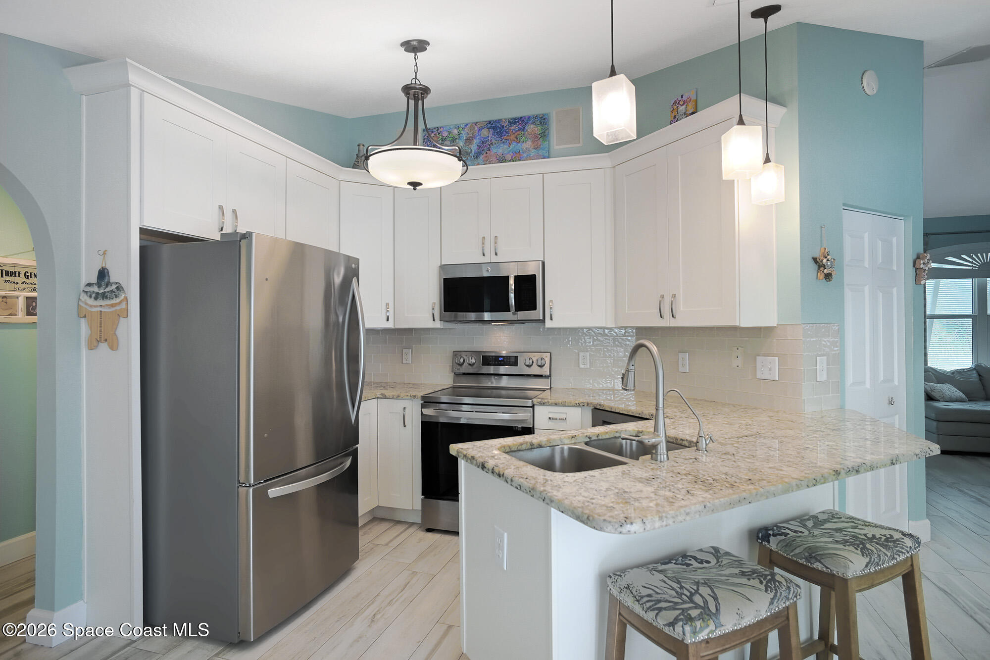 103 Matanzas Road Melbourne Beach, FL 32951 - Photo 15 of 37 a kitchen with stainless steel appliances granite countertop a stove a refrigerator a oven a sink a stove and a refrigerator with wooden floor