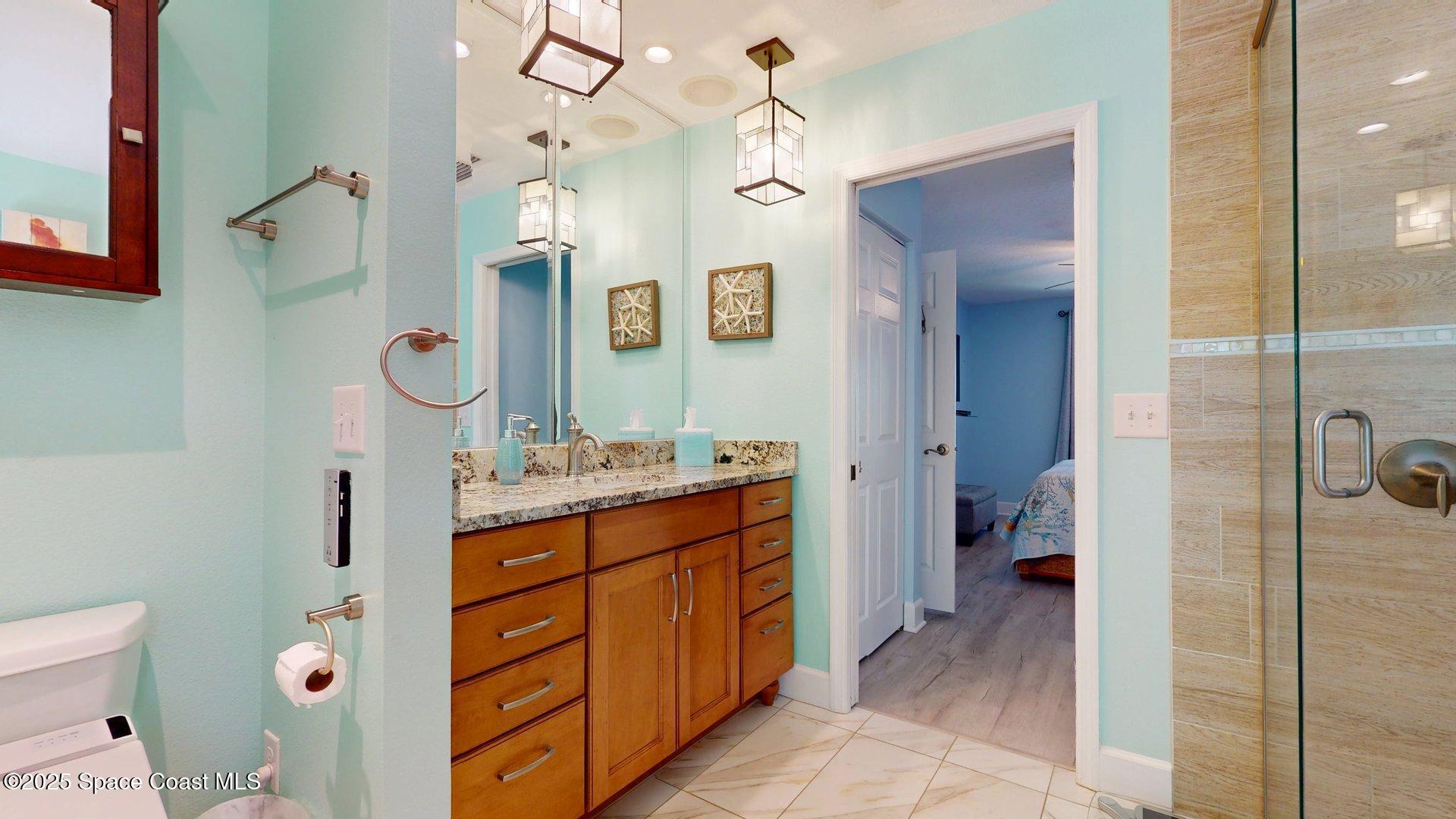 103 Matanzas Road Melbourne Beach, FL 32951 - Photo 21 of 37 a spacious bathroom with a granite countertop sink mirror and shower