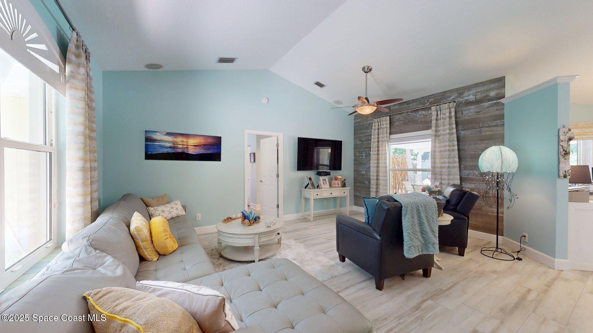 103 Matanzas Road Melbourne Beach, FL 32951 - Photo 25 of 37 a living room with furniture chandelier and a flat screen tv