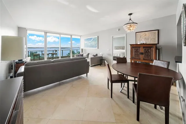 a living room with furniture a fireplace and a floor to ceiling window