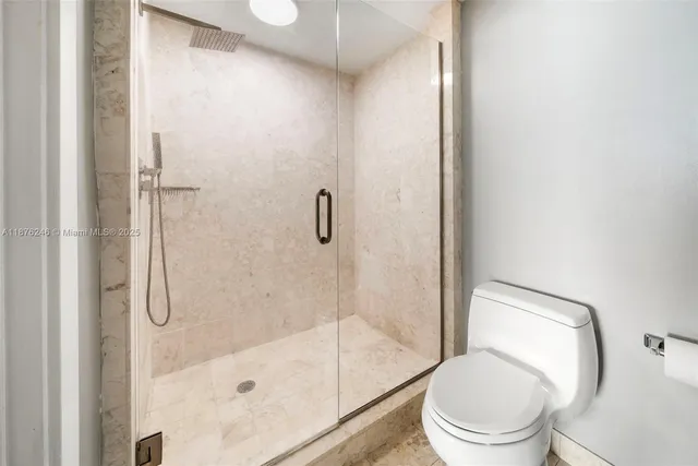 a white toilet next to a bathroom