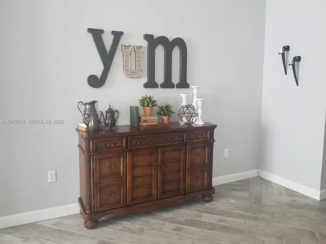 a view of a dining room with furniture and wall clock