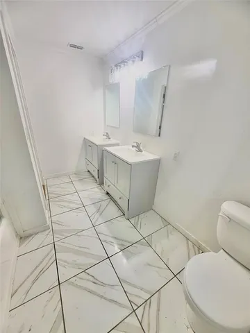 a bathroom with a sink mirror vanity and toilet