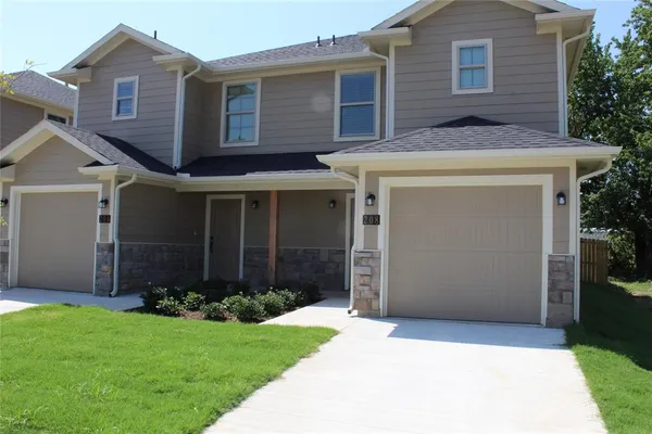 a front view of a house with a garden and garage
