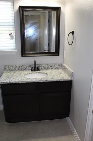 a bathroom with a sink vanity and a mirror