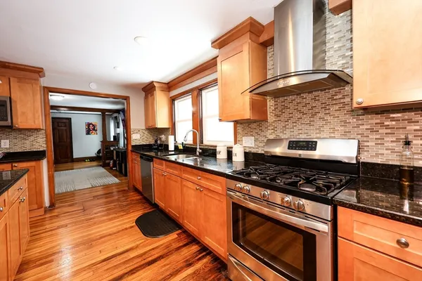 a kitchen with stainless steel appliances granite countertop a stove and a wooden cabinets