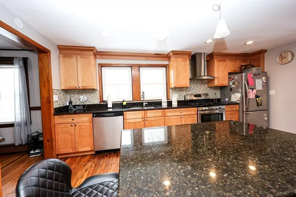 a kitchen with stainless steel appliances granite countertop a refrigerator stove oven sink and cabinets