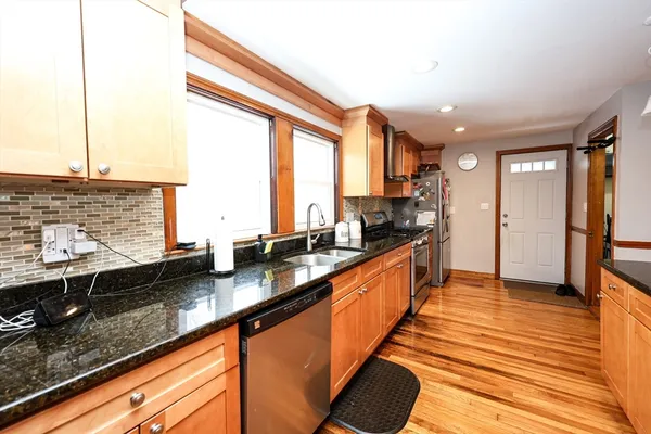 a large kitchen with granite countertop a sink and a large window