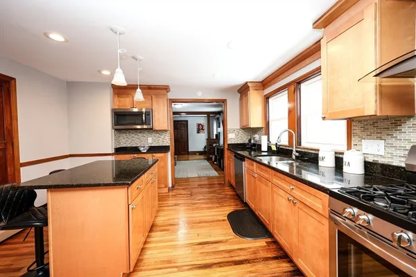 a large kitchen with stainless steel appliances granite countertop a stove a sink and a refrigerator