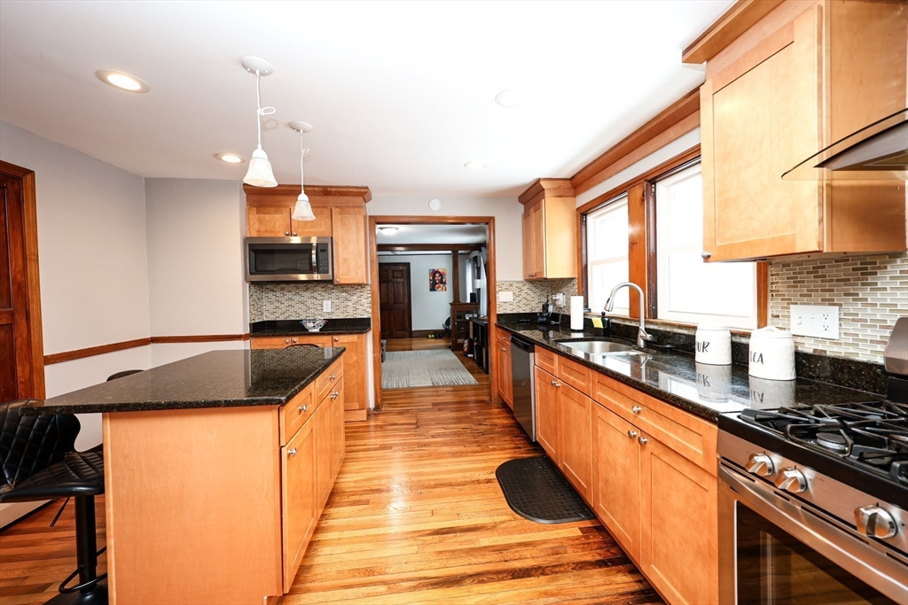 65 Clifford Street, Unit 2 Boston, MA 02136 - Photo 19 of 27 a large kitchen with stainless steel appliances granite countertop a stove a sink and a refrigerator
