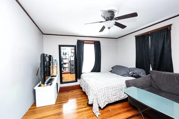 a bedroom with bed and wooden floor