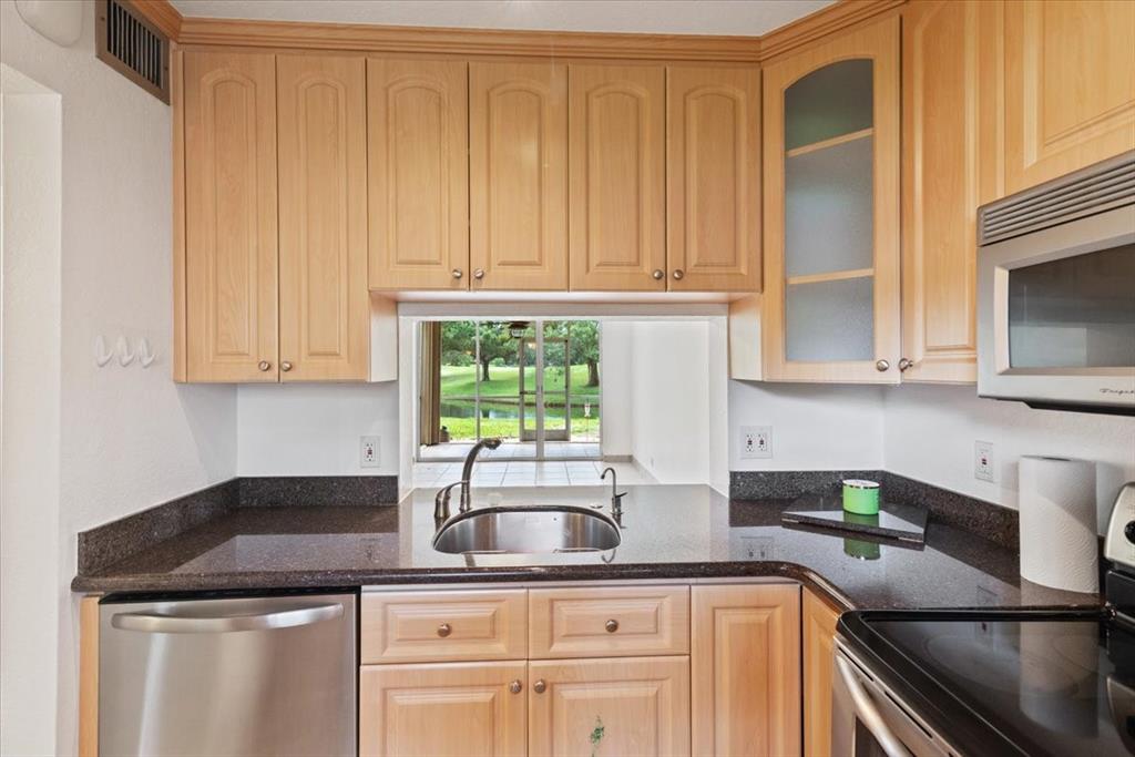 9470 Poinciana Place, Unit 1#103 Davie, FL 33324 - Photo 2 of 32 a kitchen with granite countertop a sink and a window
