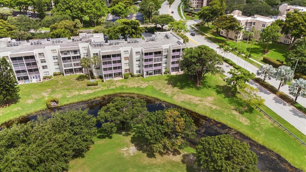9470 Poinciana Place, Unit 1#103 Davie, FL 33324 - Photo 24 of 32 a view of a garden with a building in the background