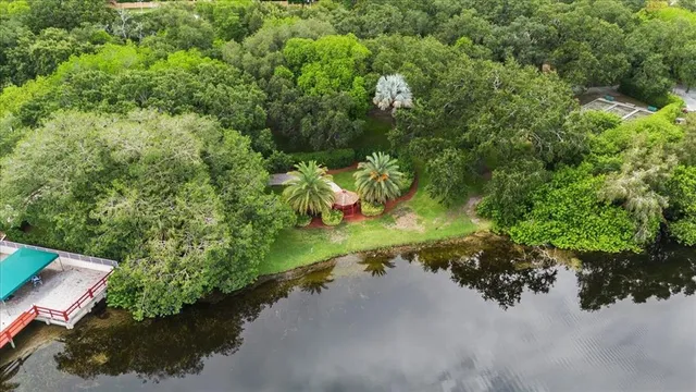 an aerial view of a house with a yard and lake view