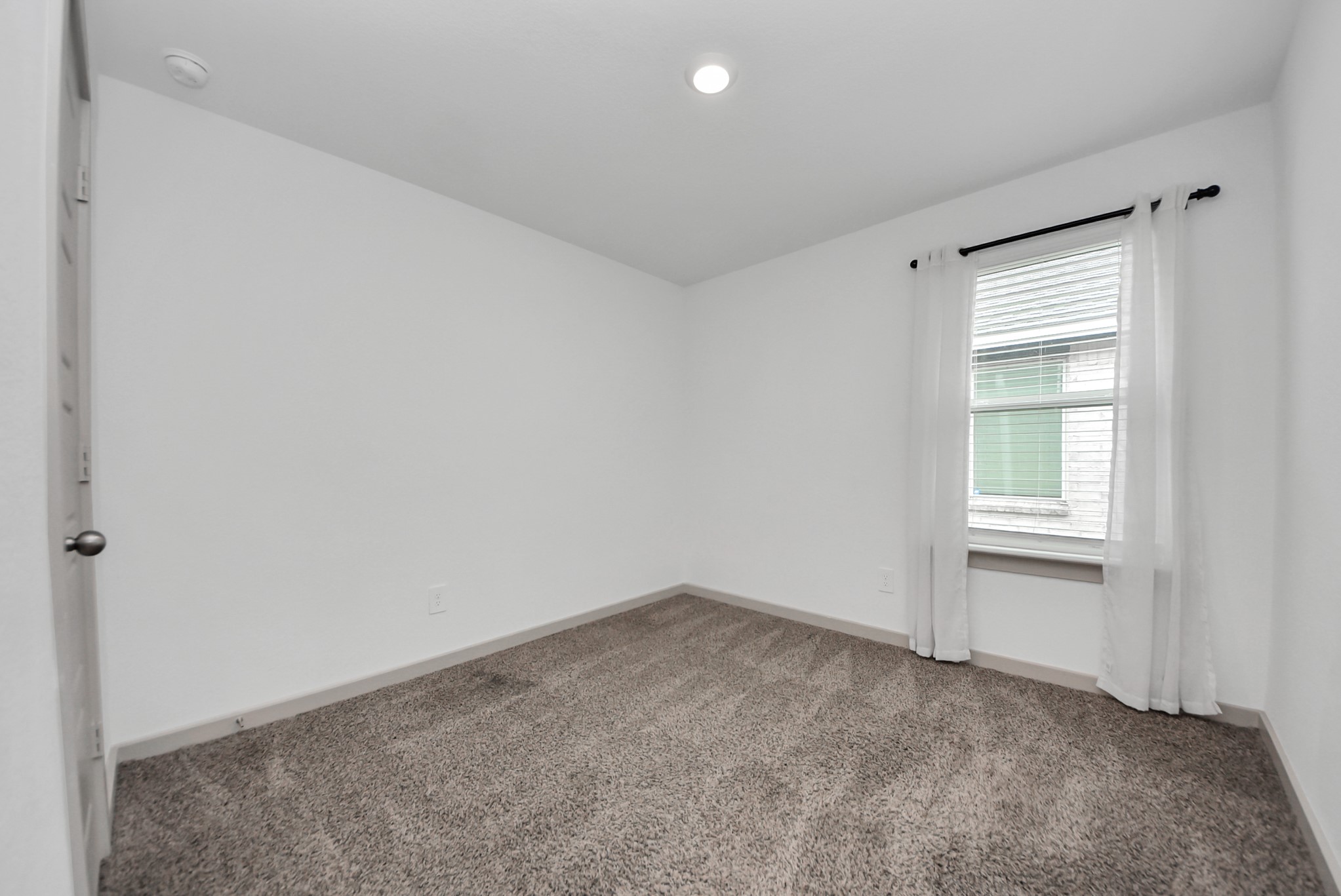 7911 Wrangler Shack Lane Rosharon, TX 77583 - Photo 18 of 40 Bright and cozy room featuring neutral carpeting, fresh white walls, and a window that invites natural light. Perfect for a bedroom or home office.