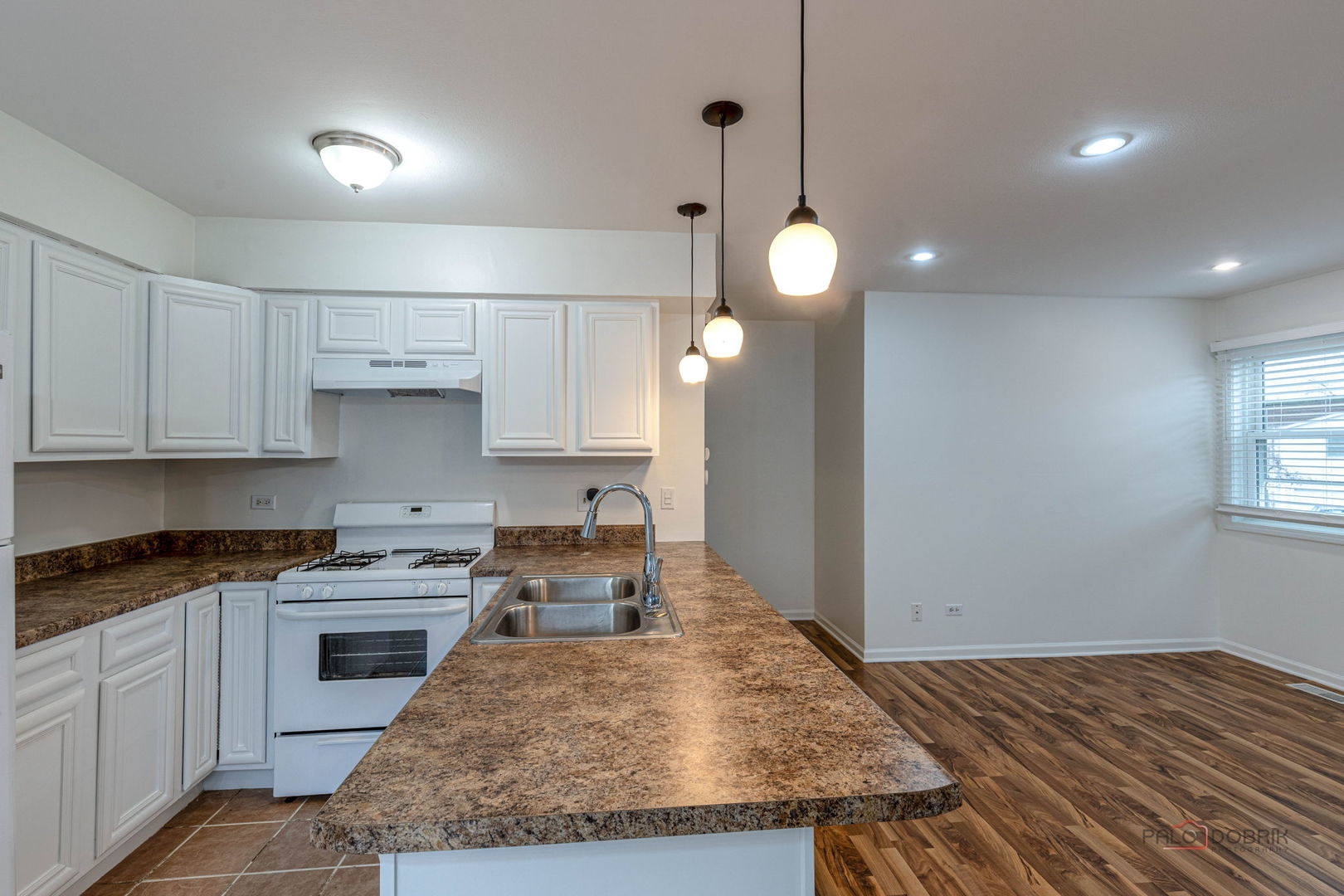 526 Inverrary Lane Deerfield, IL 60015 - Photo 5 of 8 a open kitchen with kitchen island a stove a sink a center island and wooden floor