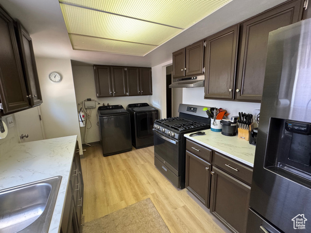 527 Palisade Drive Moab, UT 84532 - Photo 4 of 51 Kitchen featuring stainless steel fridge, independent washer and dryer, range with gas stovetop, under cabinet range hood, and light wood-style flooring