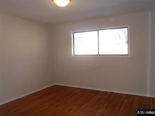 1305 Hot Springs Road Reno, NV 89521 - Photo 9 of 13 an empty room with wooden floor and windows