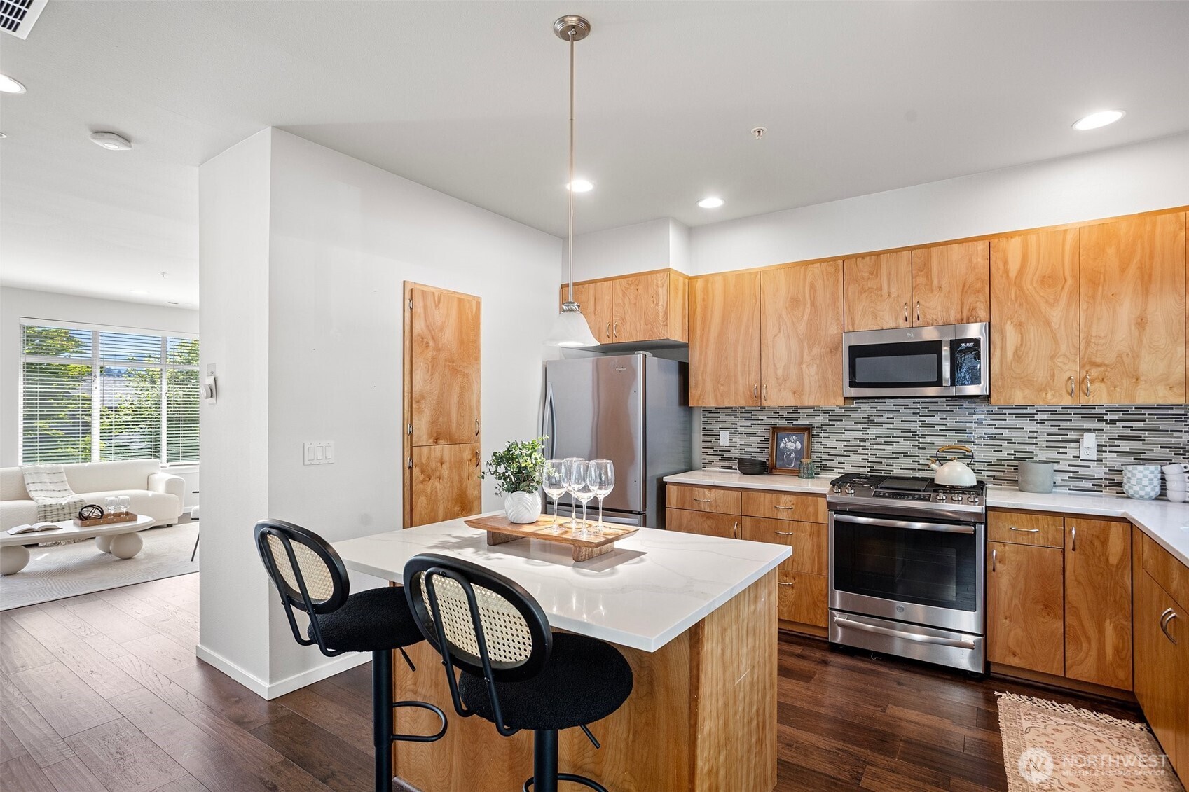 83 Sky Ridge Road Northwest Issaquah, WA 98027 - Photo 11 of 28 a kitchen with stainless steel appliances granite countertop a stove top oven a sink dishwasher a dining table and chairs with wooden floor