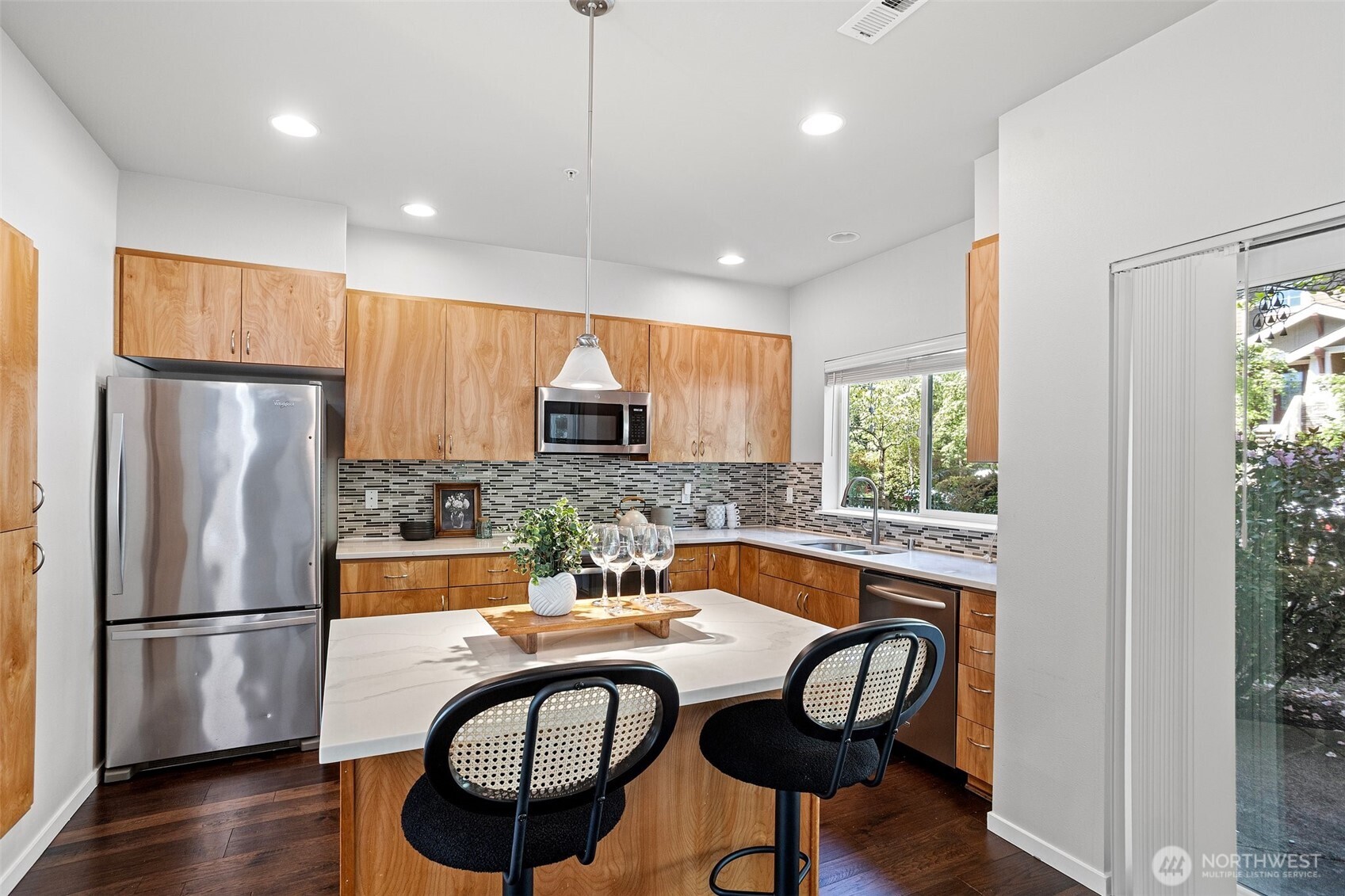 83 Sky Ridge Road Northwest Issaquah, WA 98027 - Photo 12 of 28 a kitchen with stainless steel appliances granite countertop a refrigerator a stove a sink dishwasher a dining table and chairs with wooden floor