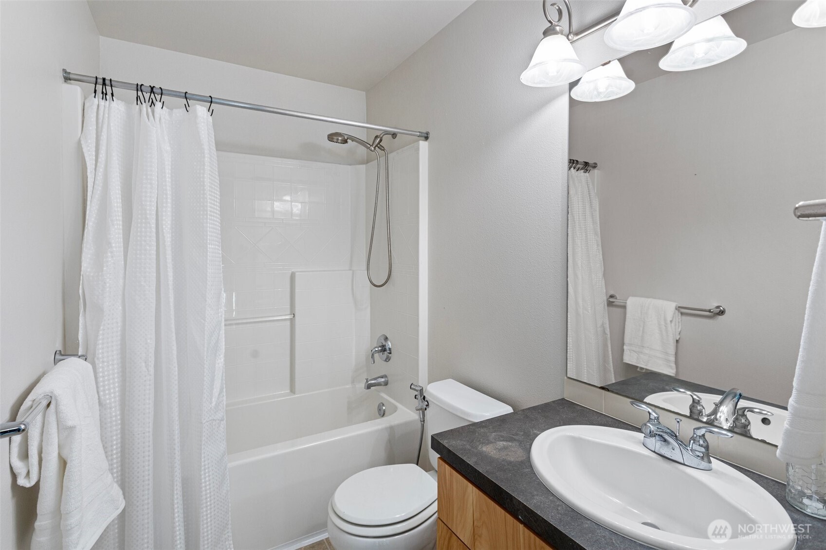 83 Sky Ridge Road Northwest Issaquah, WA 98027 - Photo 22 of 28 a bathroom with a sink a toilet a mirror a bathtub and shower