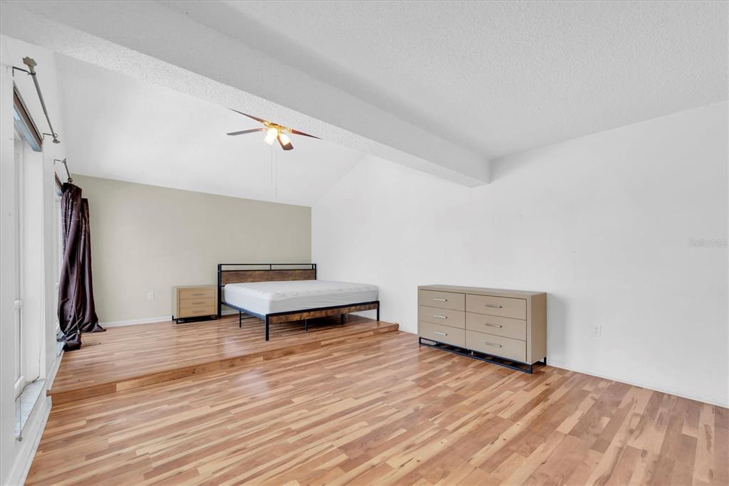 171 Medallion Boulevard, Unit F Madeira Beach, FL 33708 - Photo 12 of 30 a room with a bench and a wooden floor