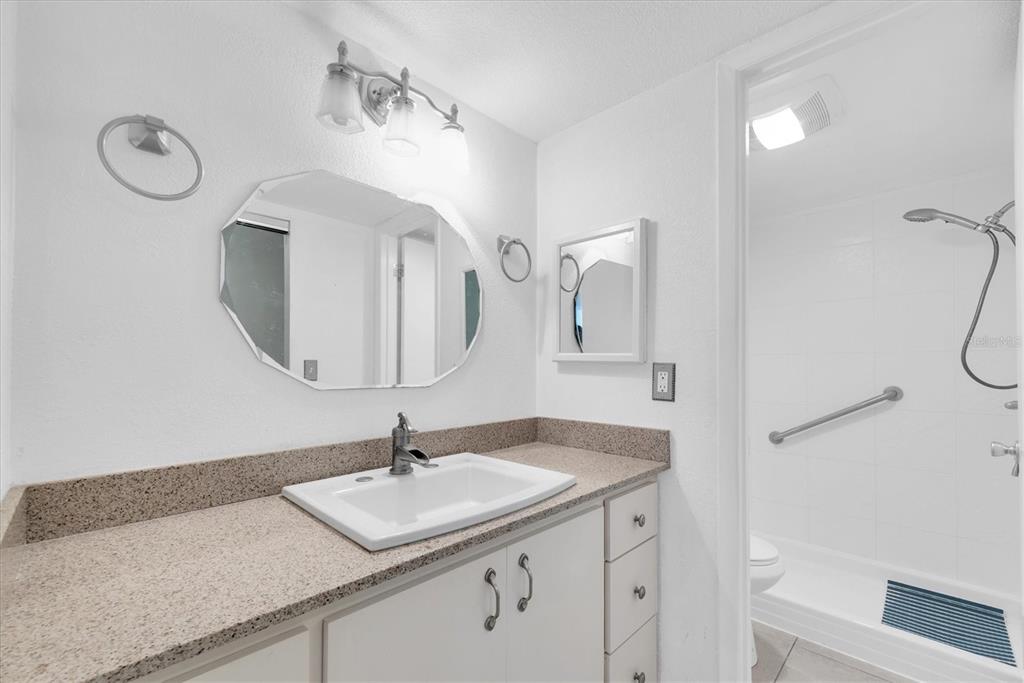 171 Medallion Boulevard, Unit F Madeira Beach, FL 33708 - Photo 15 of 30 a bathroom with a sink vanity and a mirror
