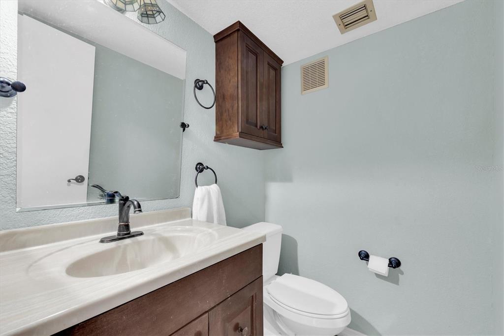 171 Medallion Boulevard, Unit F Madeira Beach, FL 33708 - Photo 18 of 30 a bathroom with a sink a toilet and mirror
