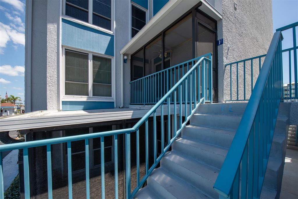 171 Medallion Boulevard, Unit F Madeira Beach, FL 33708 - Photo 2 of 30 a view of balcony with wooden floor and stairs