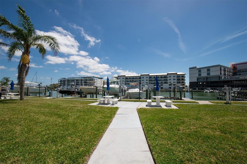 171 Medallion Boulevard, Unit F Madeira Beach, FL 33708 - Photo 24 of 30 a view of a swimming pool and a yard
