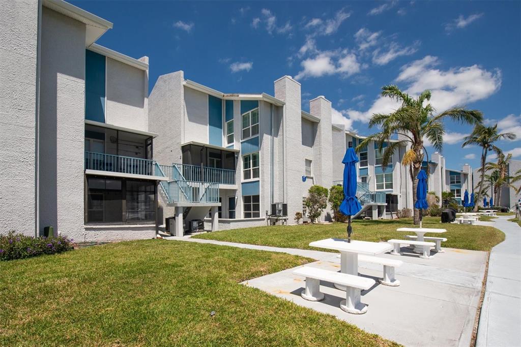 171 Medallion Boulevard, Unit F Madeira Beach, FL 33708 - Photo 25 of 30 a front view of building with yard