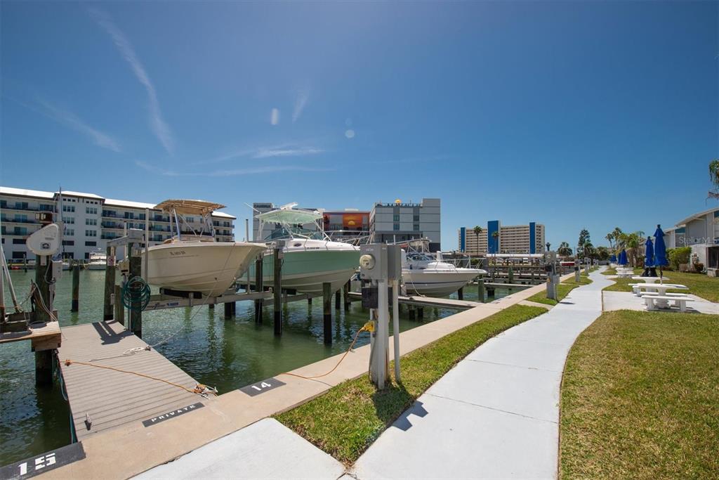 171 Medallion Boulevard, Unit F Madeira Beach, FL 33708 - Photo 26 of 30 a view of a swimming pool with outdoor seating and plants