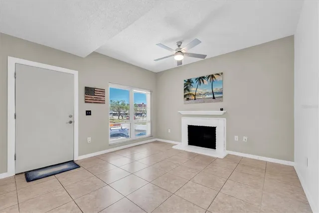 an empty room with windows and fireplace