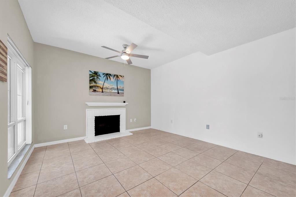 171 Medallion Boulevard, Unit F Madeira Beach, FL 33708 - Photo 5 of 30 an empty room with windows and fireplace