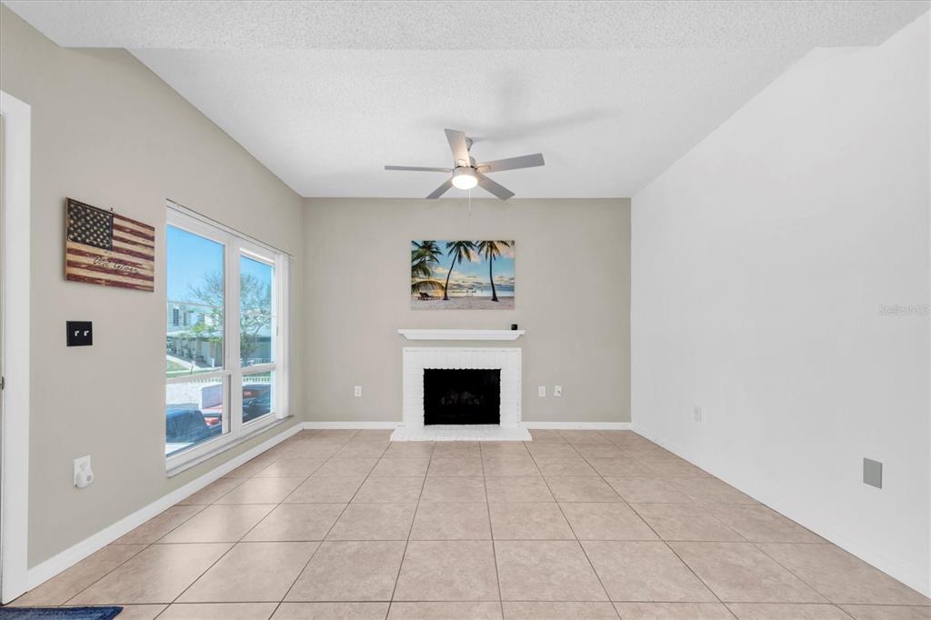 171 Medallion Boulevard, Unit F Madeira Beach, FL 33708 - Photo 6 of 30 a view of an empty room with a fireplace and a window