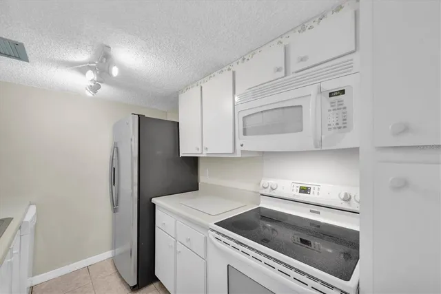 a kitchen with stainless steel appliances granite countertop a sink a refrigerator and a counter top